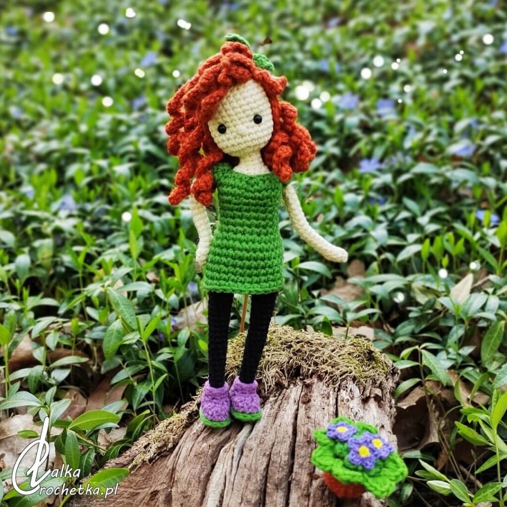 lalka crochetka amigurumi Wiola Fiolek stojaca na leśnej polanie personalizowana postac inspirowana natura